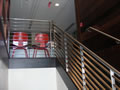 Stainless steel welded & grained matched railing system over closed walnut buttress scissor stair, Napa, CA